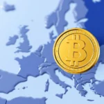 Eine goldene Bitcoin-Münze liegt auf einer blauen Karte von Europa.